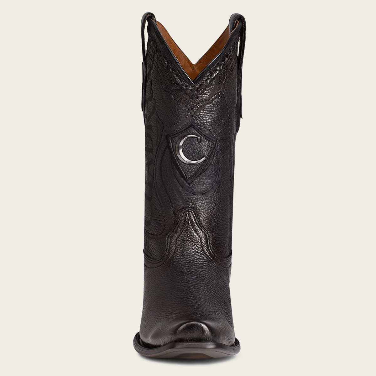 Stylish black leather boot with intricate engraving and a metallic monogram accent.