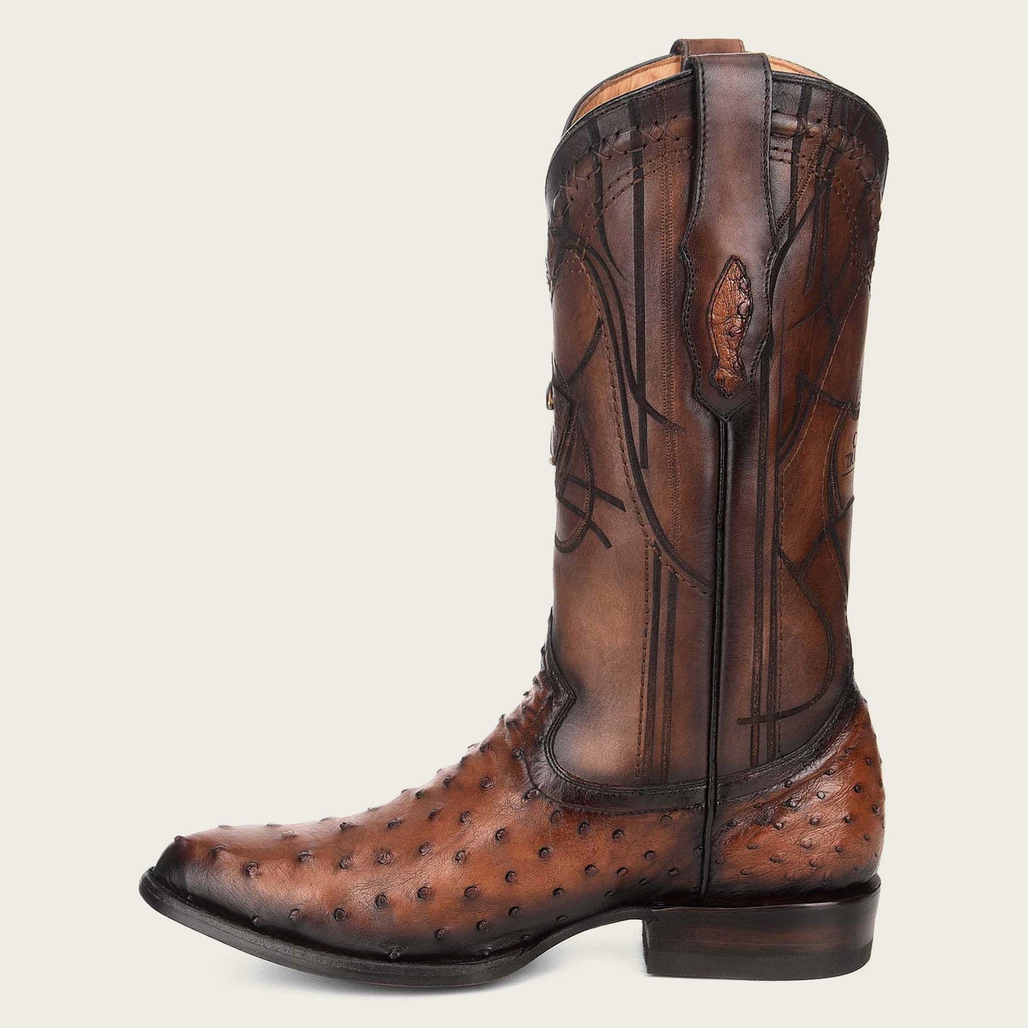 Stylish brown leather boot with intricate engraving and a timeless design.