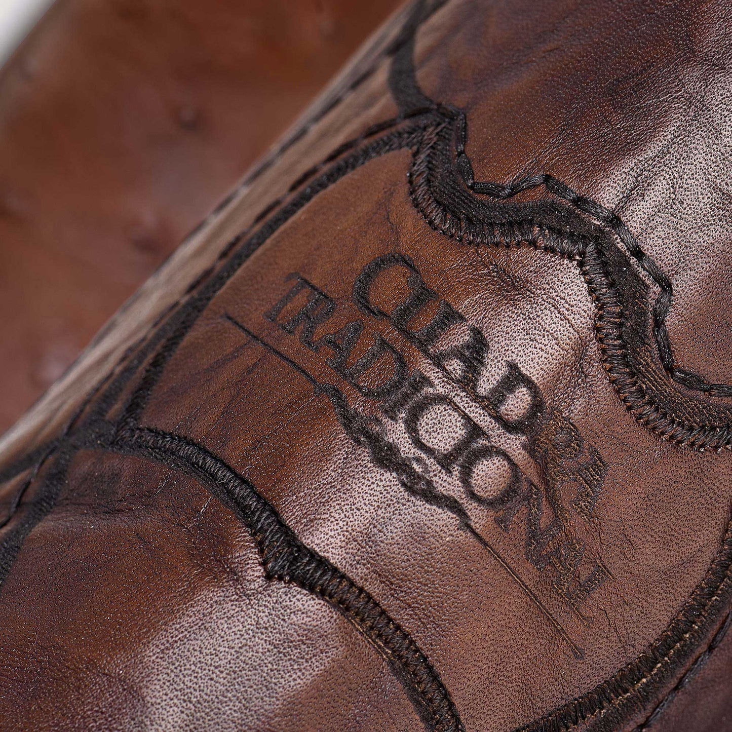 Stylish brown leather boot with intricate engraving and a timeless design.