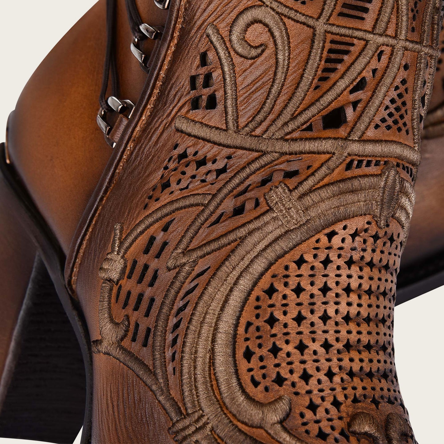 Embroidered honey leather bootie with organic motifs and metallic details.