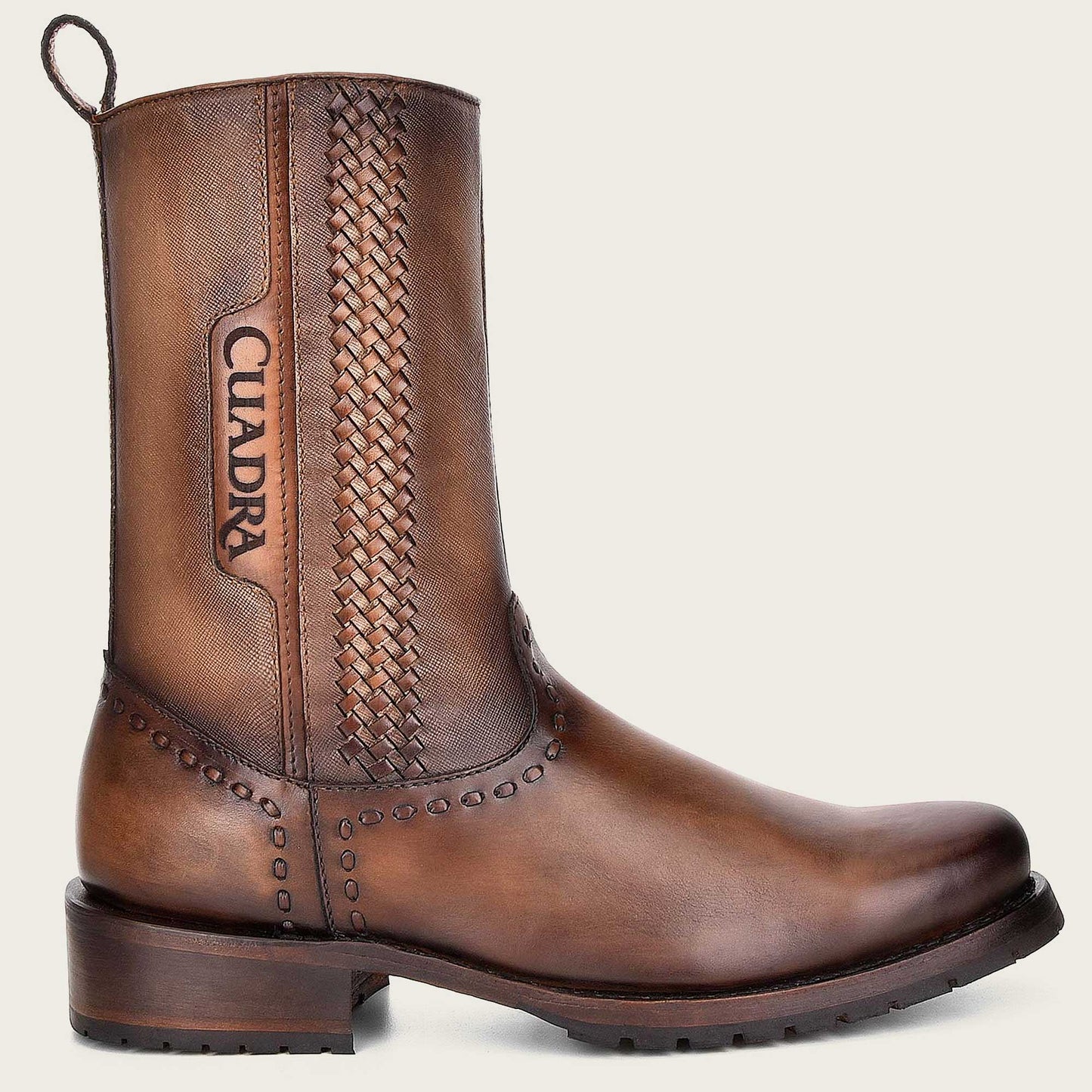 A skillfully crafted boot made of honey-colored leather with intricate handwoven details